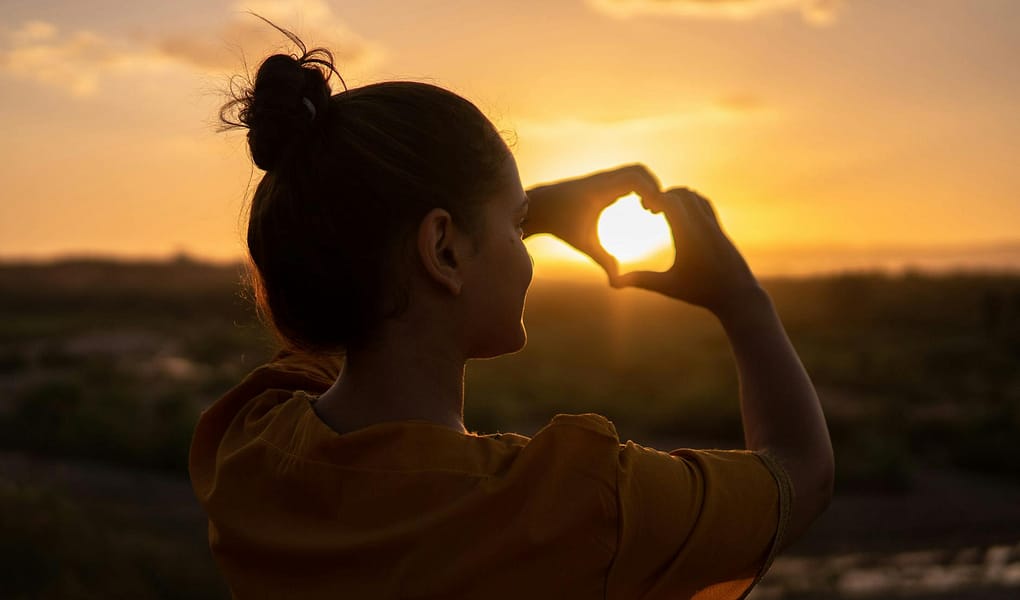 woman doing hand heart sign
