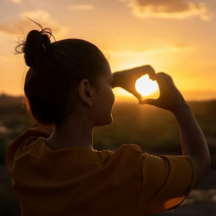 woman doing hand heart sign