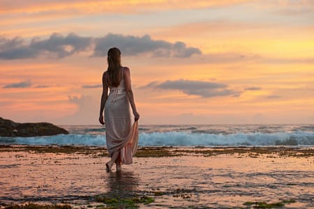 woman standing on sand near shoreline